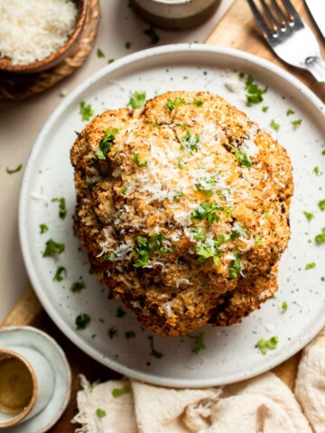 Whole Roasted Cauliflower features a flavorful crust and tender, buttery florets. It is a stunning vegetarian centerpiece that is easy to prepare. | aheadofthyme.com