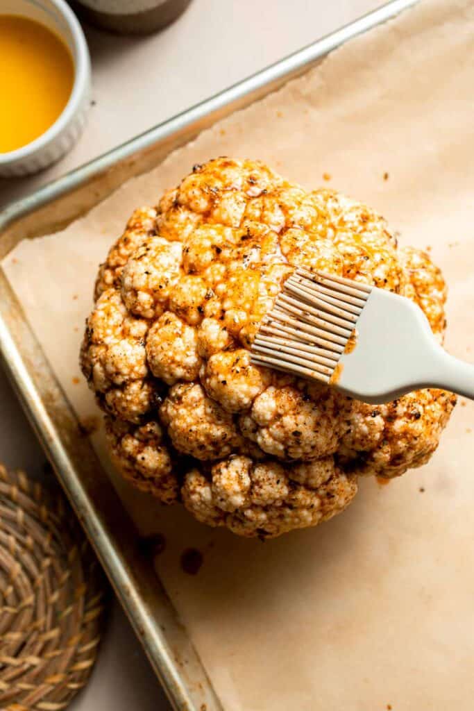 Whole Roasted Cauliflower features a flavorful crust and tender, buttery florets. It is a stunning vegetarian centerpiece that is easy to prepare. | aheadofthyme.com