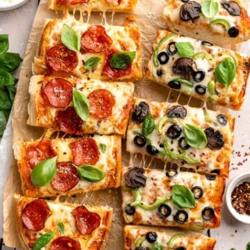 Quick and easy French Bread Pizza is loaded with garlic butter, customizable toppings, and a balance of crispy crust and gooey cheese. Ready in 20 minutes! | aheadofthyme.com