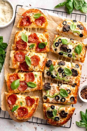 Quick and easy French Bread Pizza is loaded with garlic butter, customizable toppings, and a balance of crispy crust and gooey cheese. Ready in 20 minutes! | aheadofthyme.com