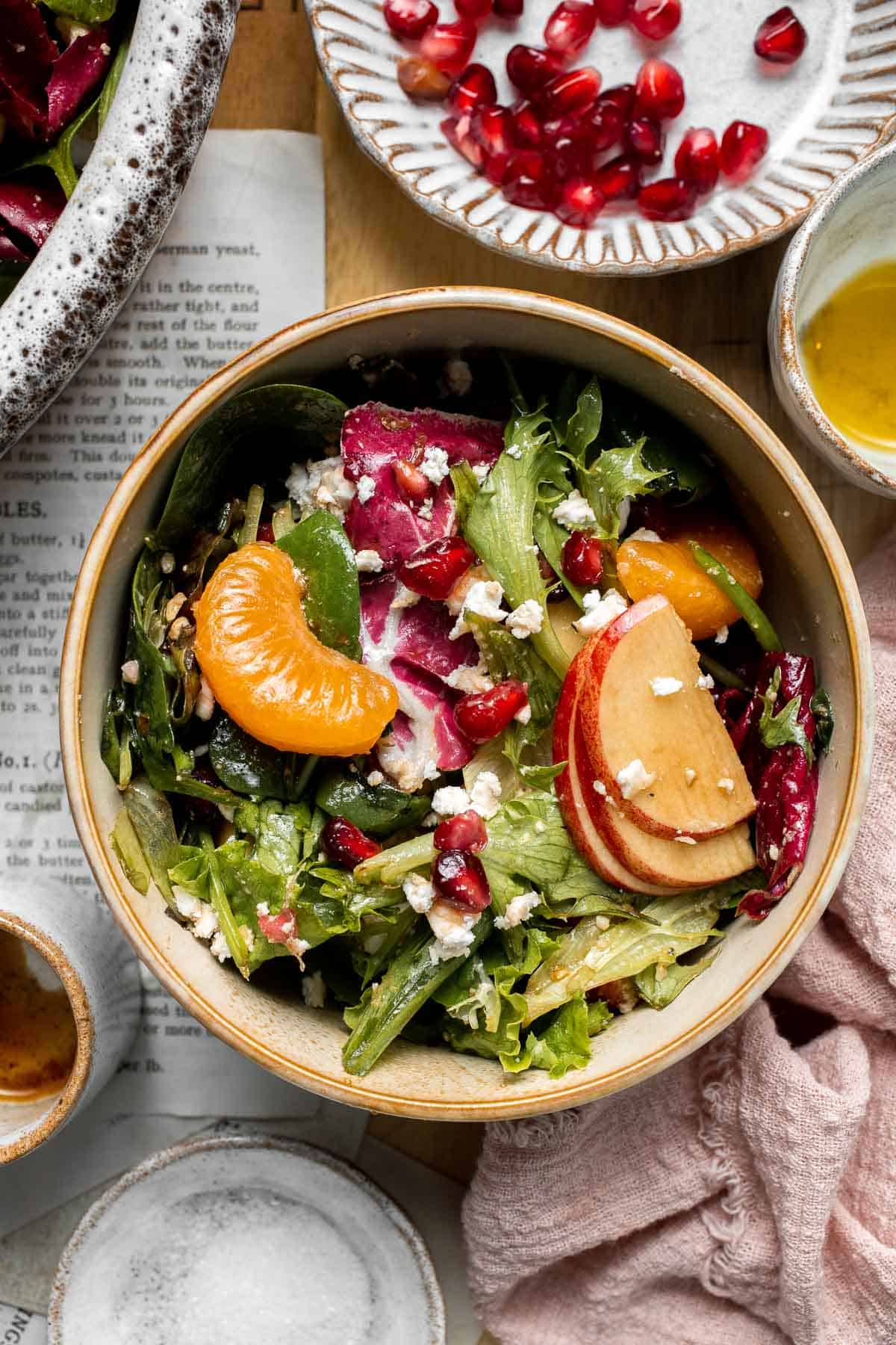 Festive Winter Pomegranate Salad is studded with sweet pomegranate seeds, apples, oranges, and feta, all tossed in a homemade balsamic vinaigrette. | aheadofthyme.com