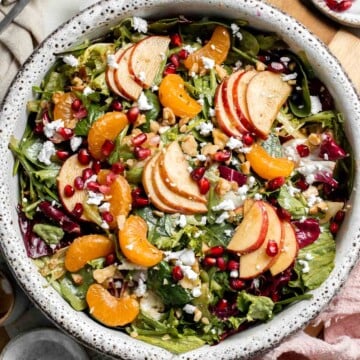 Festive Winter Pomegranate Salad is studded with sweet pomegranate seeds, apples, oranges, and feta, all tossed in a homemade balsamic vinaigrette. | aheadofthyme.com