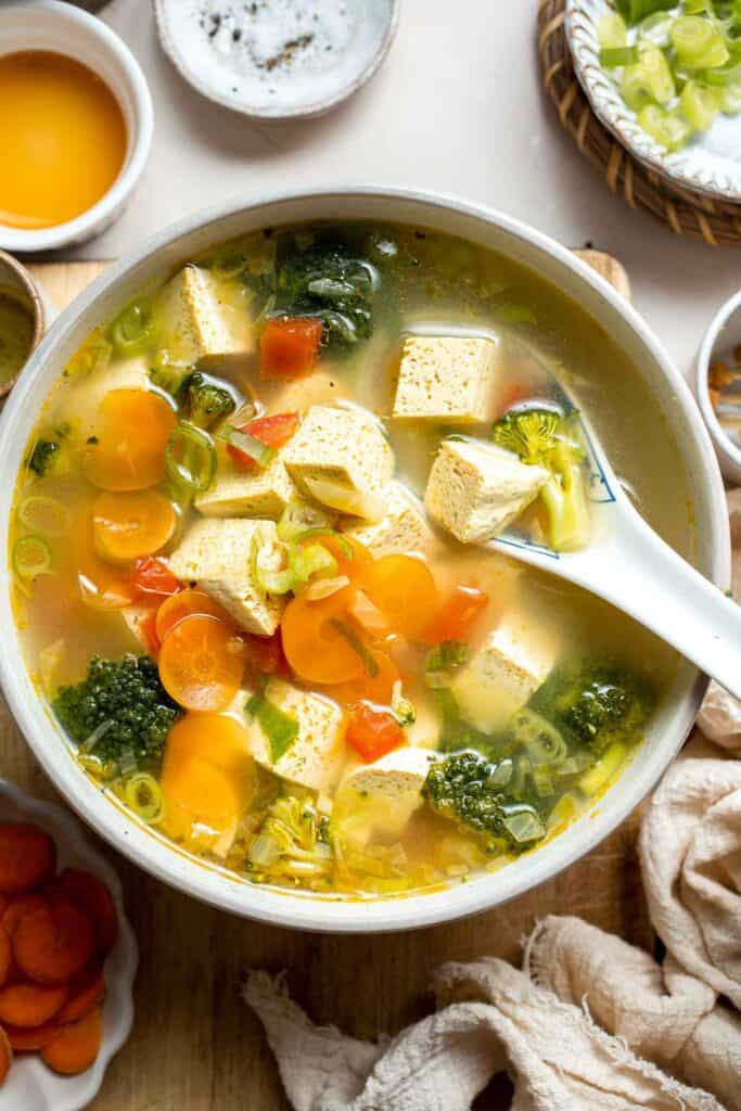 This homemade Tofu Soup is light and satisfying — with tender tofu cubes, vibrant veggies, and a savory broth for a deep, rich flavor that will warm you up. | aheadofthyme.com
