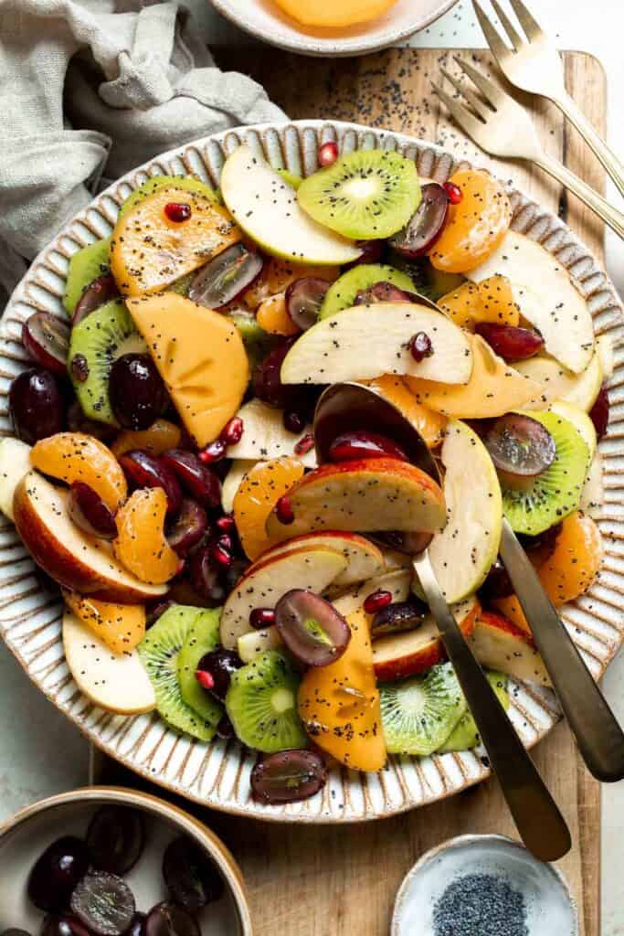 Easy Winter Fruit Salad combines juicy citrus, sweet grapes, crisp apples, permissions, and tart pomegranate, tossed together with a honey-lime dressing. | aheadofthyme.com