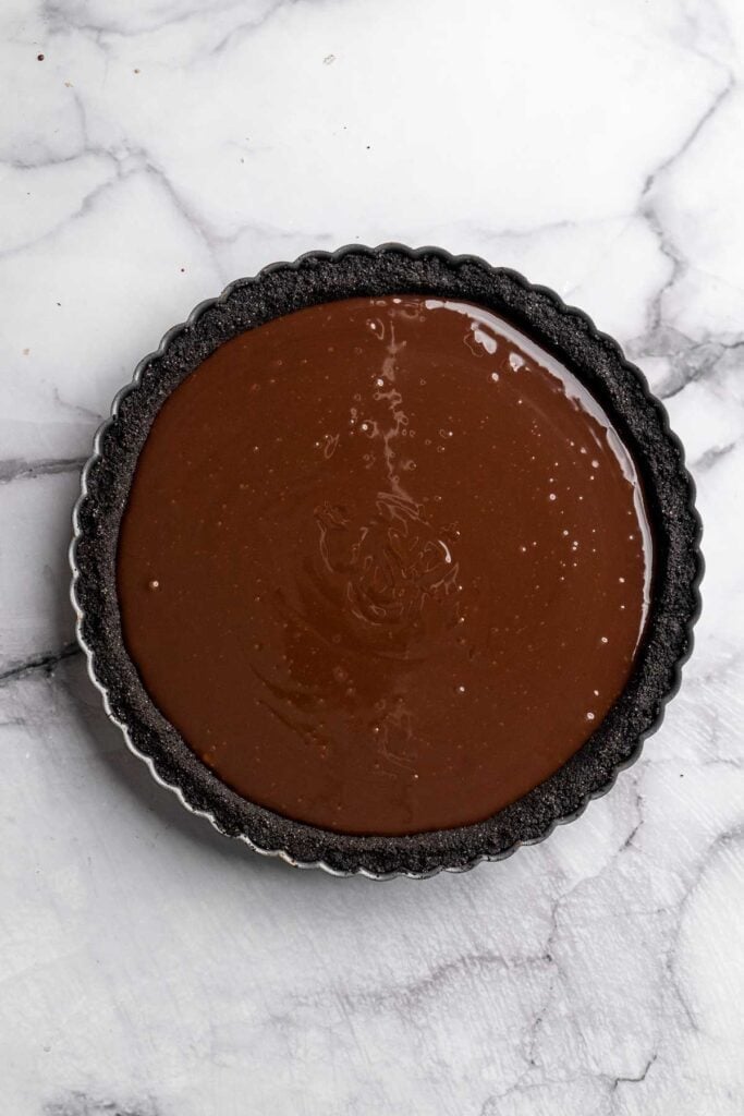 This Chocolate Tart is rich, decadent, and layered with the perfect balance of chocolate ganache and Oreo cookie crust. Way easier to make than you think! | aheadofthyme.com
