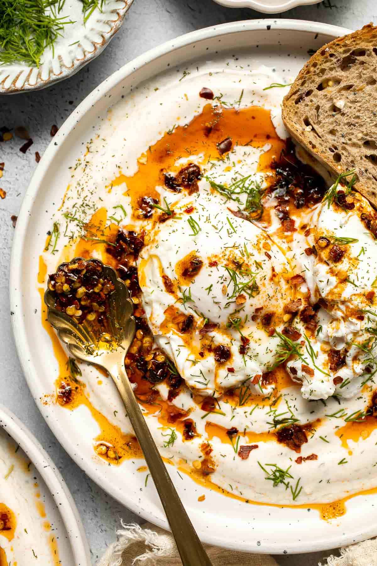 Turkish Eggs, or Çılbır, are a rich and comforting combination of poached eggs nestled over garlicky, herbed yogurt and drizzled with a spiced chili oil. | aheadofthyme.com