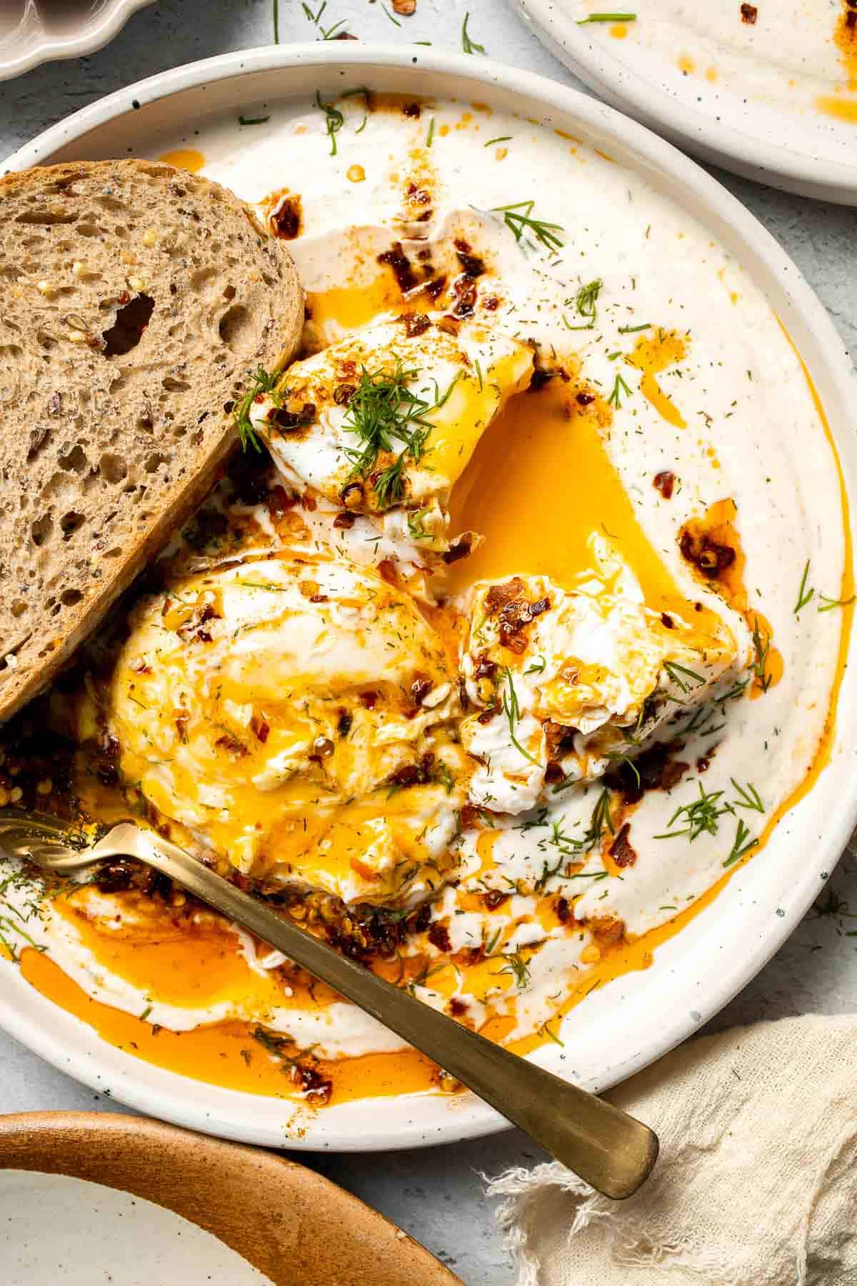 Turkish Eggs, or Çılbır, are a rich and comforting combination of poached eggs nestled over garlicky, herbed yogurt and drizzled with a spiced chili oil. | aheadofthyme.com