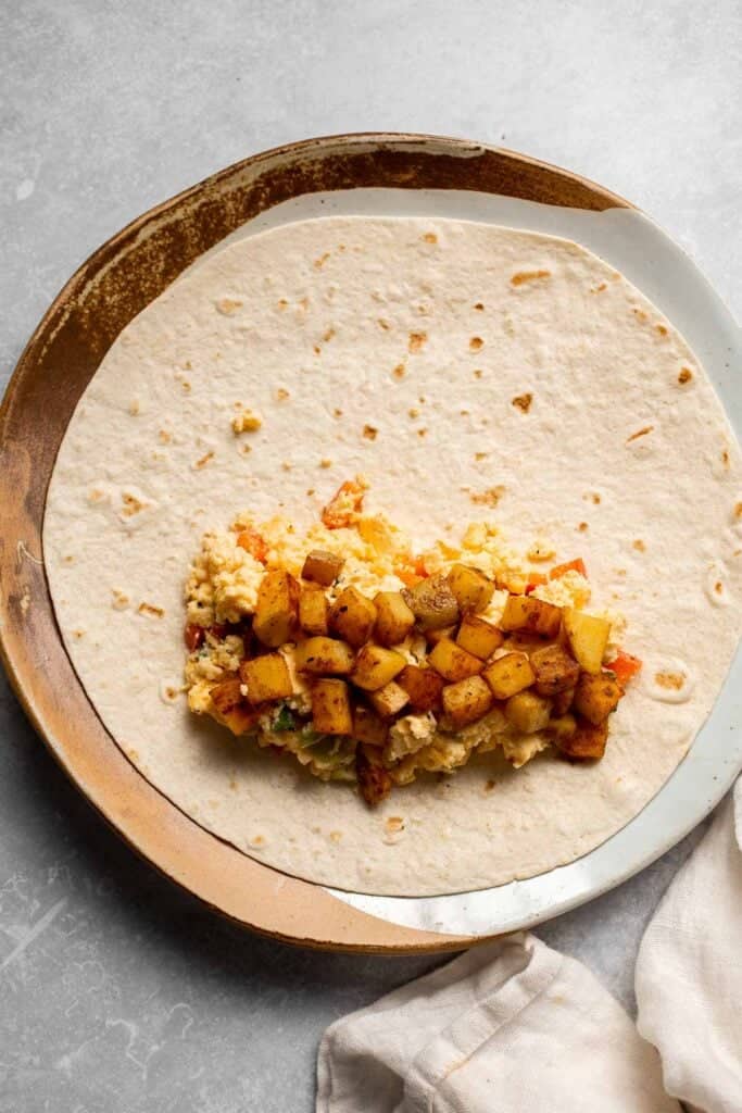 Vegetarian Breakfast Burritos are packed with crispy potatoes, veggies, fluffy eggs, cheese, and avocado. A balanced breakfast that actually keeps you full! | aheadofthyme.com