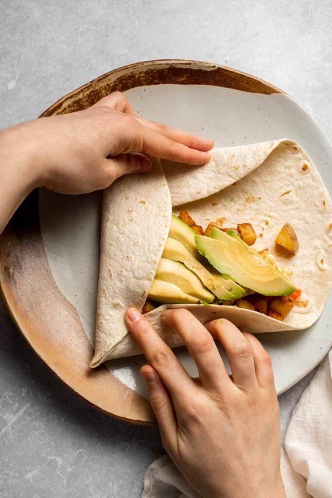 Vegetarian Breakfast Burritos are packed with crispy potatoes, veggies, fluffy eggs, cheese, and avocado. A balanced breakfast that actually keeps you full! | aheadofthyme.com