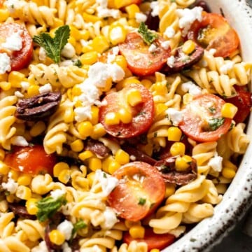 Fresh and zesty, this Corn and Tomato Pasta Salad features feta, herbs, and homemade dressing. Perfect for summer barbecues and gatherings! | aheadofthyme.com