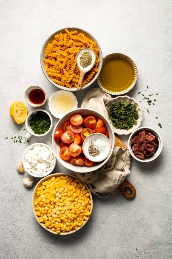 Fresh and zesty, this Corn and Tomato Pasta Salad features feta, herbs, and homemade dressing. Perfect for summer barbecues and gatherings! | aheadofthyme.com
