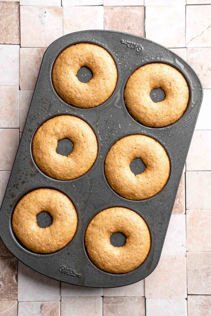Indulge in the flavors of fall with these delicious baked apple cider donuts coated in spiced cinnamon sugar. An easy to make and cozy fall treat! | aheadofthyme.com