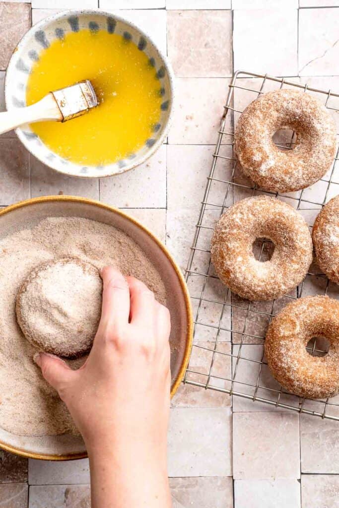 Indulge in the flavors of fall with these delicious baked apple cider donuts coated in spiced cinnamon sugar. An easy to make and cozy fall treat! | aheadofthyme.com
