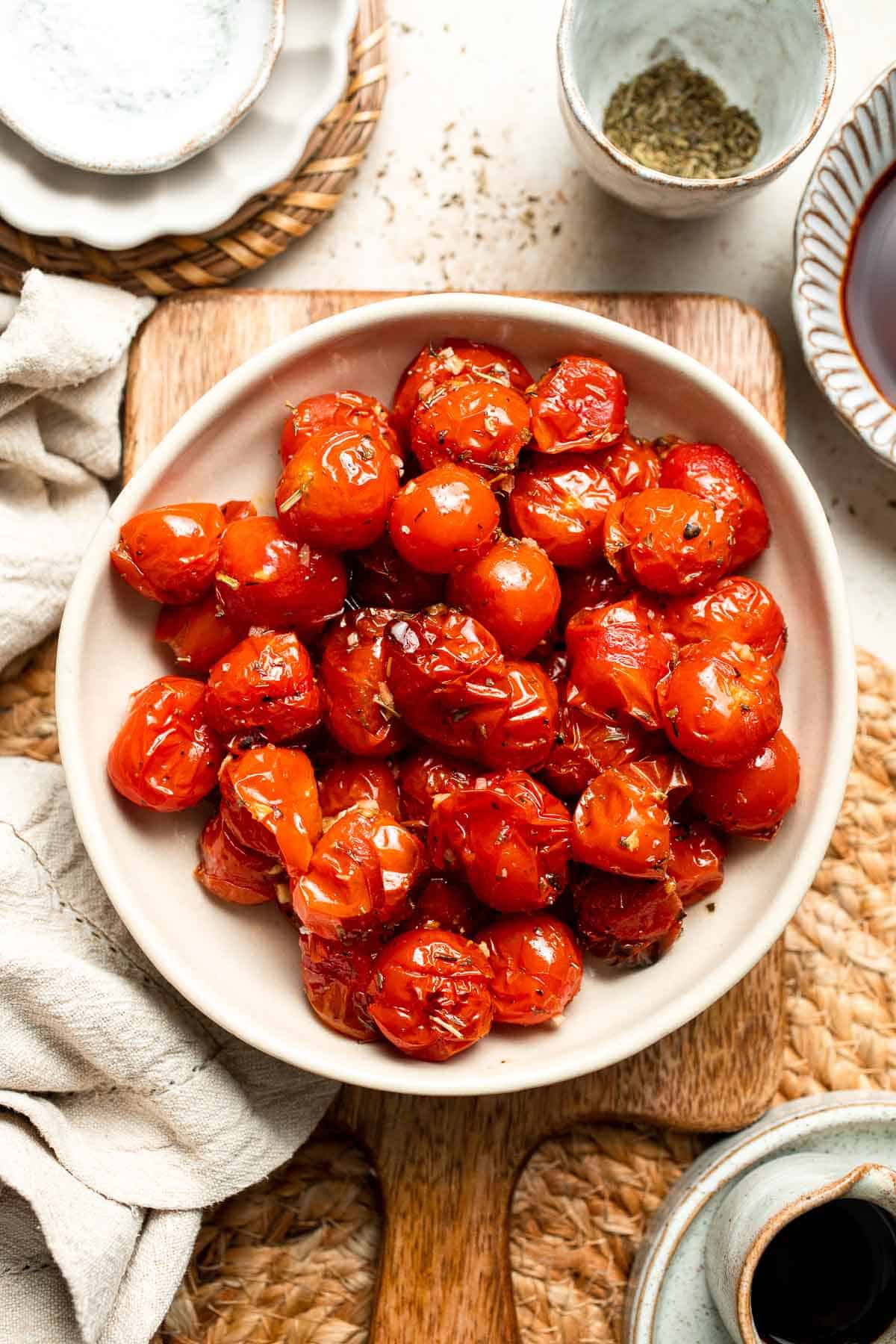 Easy to make and bursting with flavor, these juicy Roasted Cherry Tomatoes with garlic, herbs, and balsamic are the perfect addition to any meal. | aheadofthyme.com
