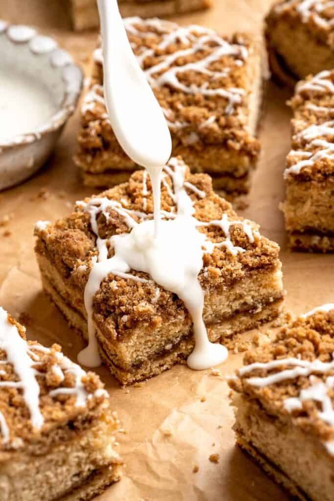 This sour cream coffee cake with cinnamon swirl is soft, buttery, and topped with crunchy streusel and vanilla glaze. Perfect for brunch or dessert. | aheadofthyme.com