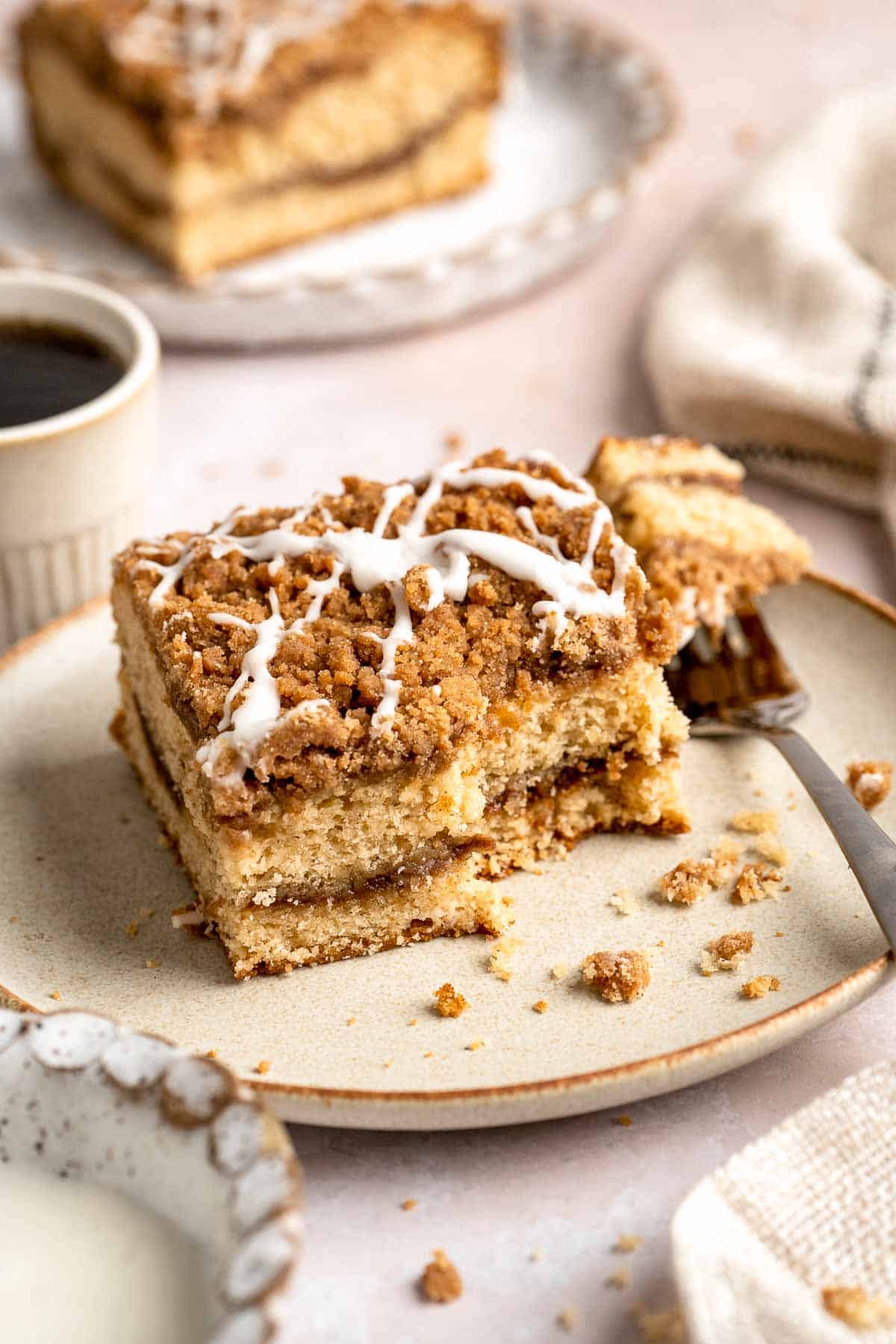 This sour cream coffee cake with cinnamon swirl is soft, buttery, and topped with crunchy streusel and vanilla glaze. Perfect for brunch or dessert. | aheadofthyme.com