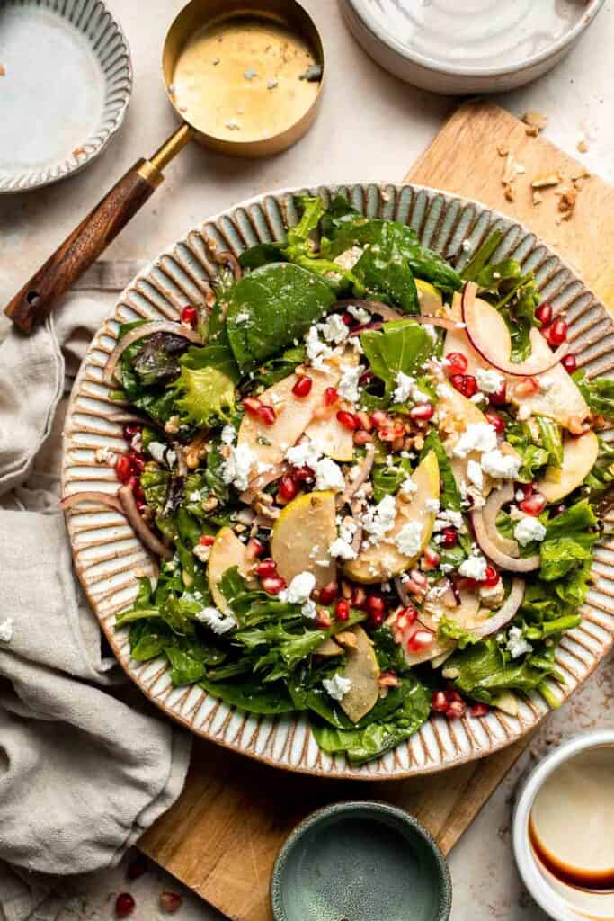 Pomegranate pear salad with walnuts, tangy cheese, and honey balsamic dressing is fresh, colorful, and perfect for holidays or everyday meals. | aheadofthyme.com