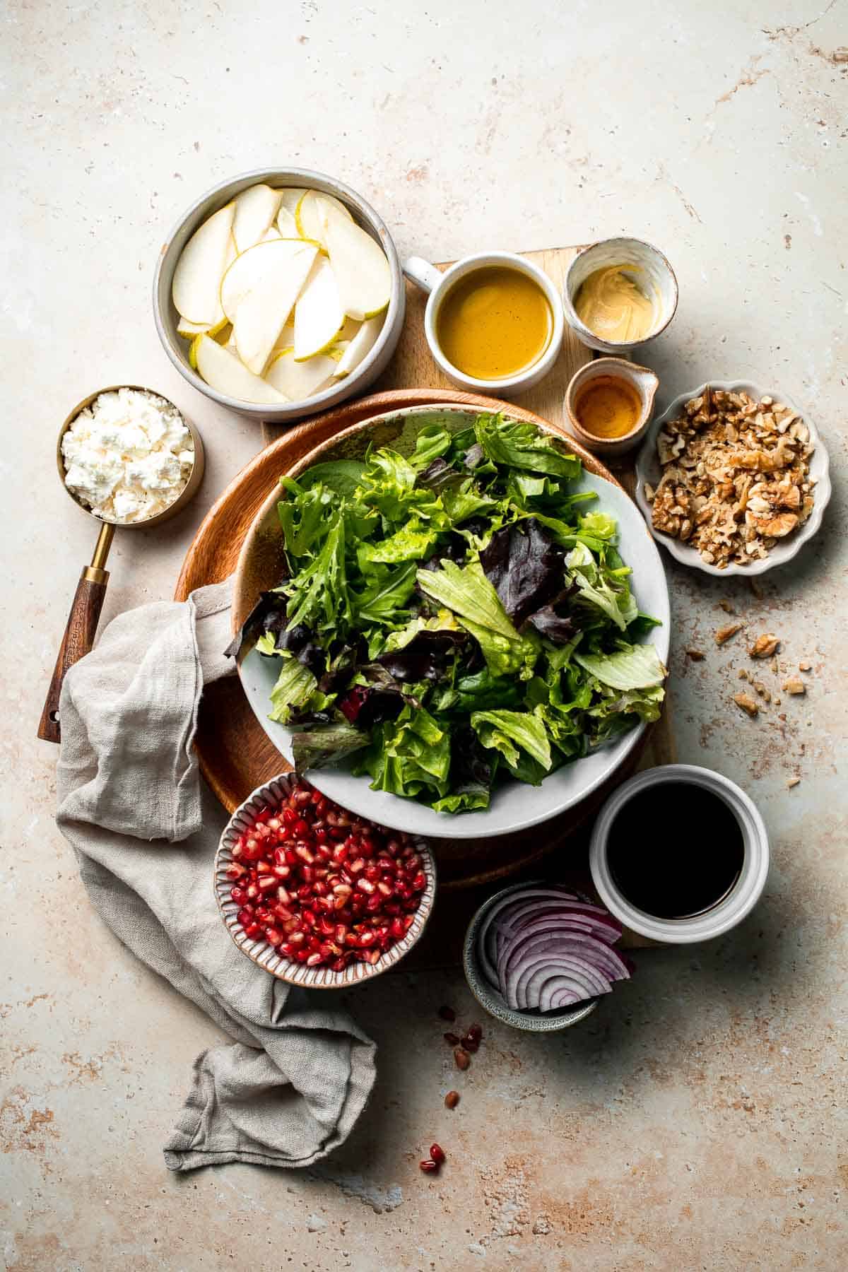 Pomegranate pear salad with walnuts, tangy cheese, and honey balsamic dressing is fresh, colorful, and perfect for holidays or everyday meals. | aheadofthyme.com