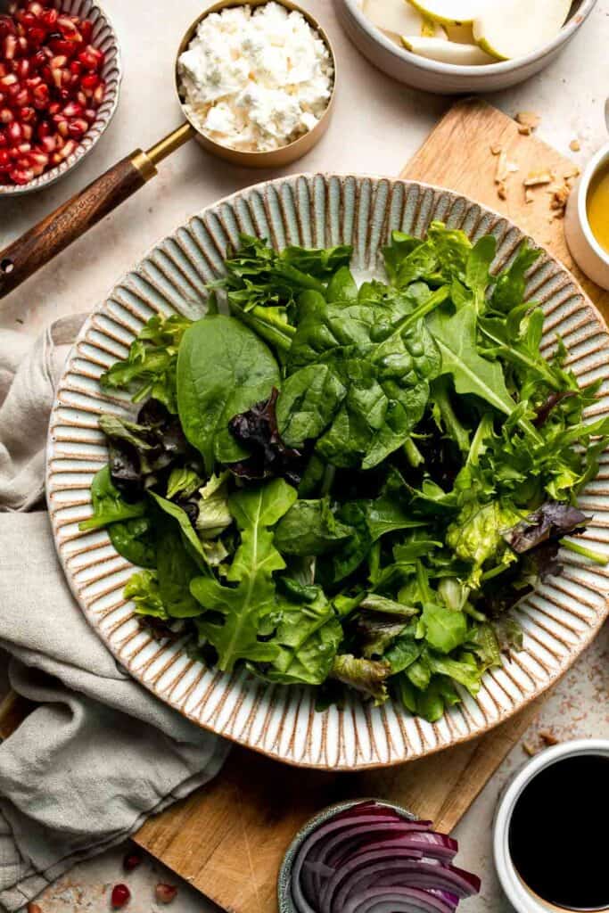 Pomegranate pear salad with walnuts, tangy cheese, and honey balsamic dressing is fresh, colorful, and perfect for holidays or everyday meals. | aheadofthyme.com