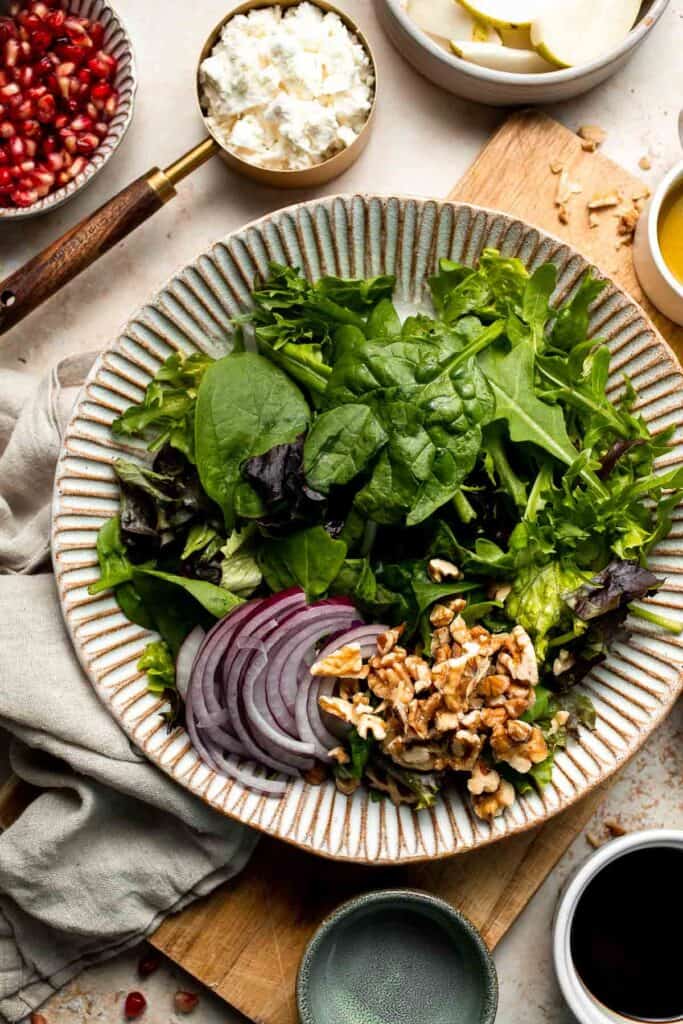 Pomegranate pear salad with walnuts, tangy cheese, and honey balsamic dressing is fresh, colorful, and perfect for holidays or everyday meals. | aheadofthyme.com