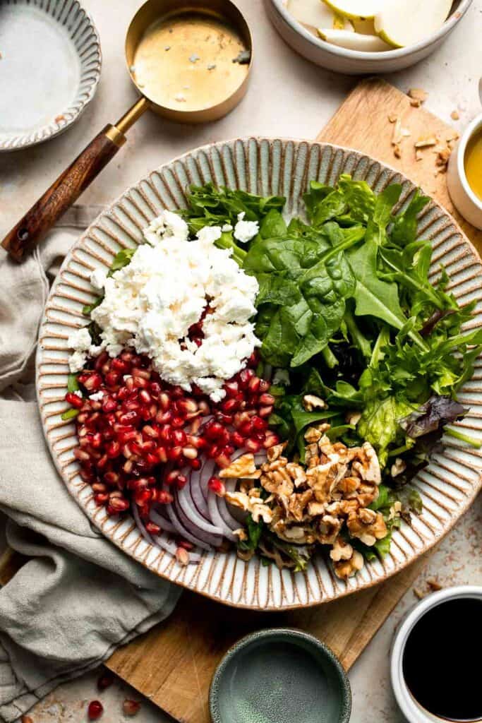 Pomegranate pear salad with walnuts, tangy cheese, and honey balsamic dressing is fresh, colorful, and perfect for holidays or everyday meals. | aheadofthyme.com