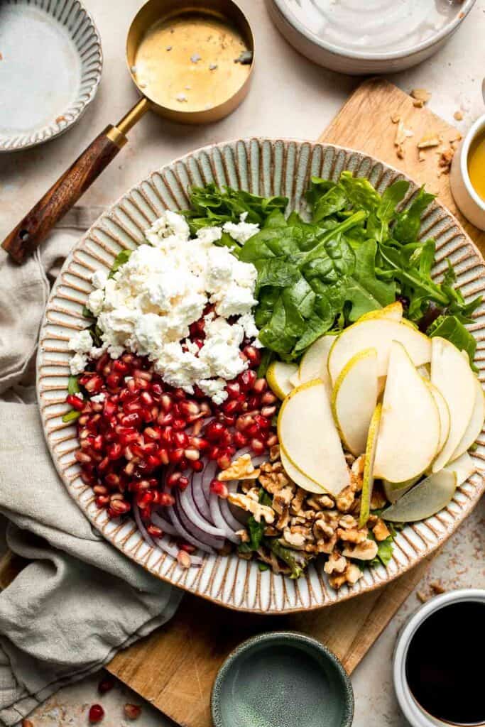 Pomegranate pear salad with walnuts, tangy cheese, and honey balsamic dressing is fresh, colorful, and perfect for holidays or everyday meals. | aheadofthyme.com