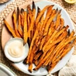 Indulge in these crispy and flavorful baked sweet potato fries, served with a creamy garlic aioli for the perfect combination of sweet and savory. | aheadofthyme.com