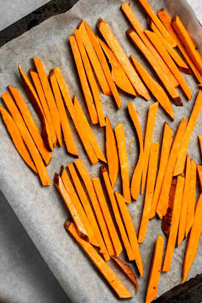 Indulge in these crispy and flavorful baked sweet potato fries, served with a creamy garlic aioli for the perfect combination of sweet and savory. | aheadofthyme.com