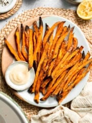 Indulge in these crispy and flavorful baked sweet potato fries, served with a creamy garlic aioli for the perfect combination of sweet and savory. | aheadofthyme.com