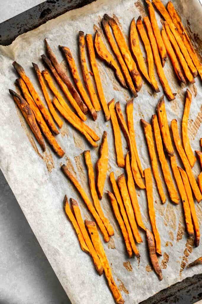 Indulge in these crispy and flavorful baked sweet potato fries, served with a creamy garlic aioli for the perfect combination of sweet and savory. | aheadofthyme.com