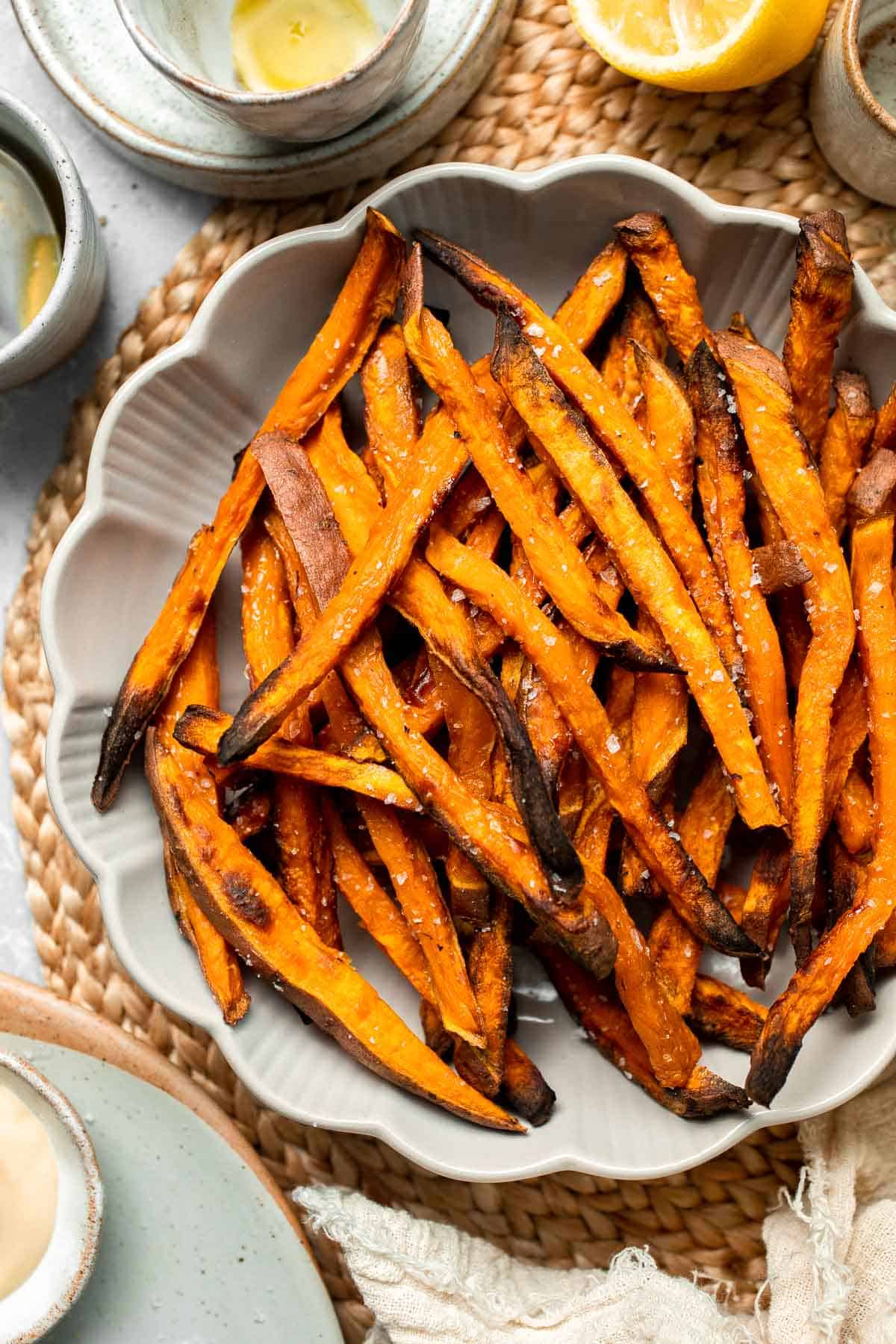Indulge in these crispy and flavorful baked sweet potato fries, served with a creamy garlic aioli for the perfect combination of sweet and savory. | aheadofthyme.com