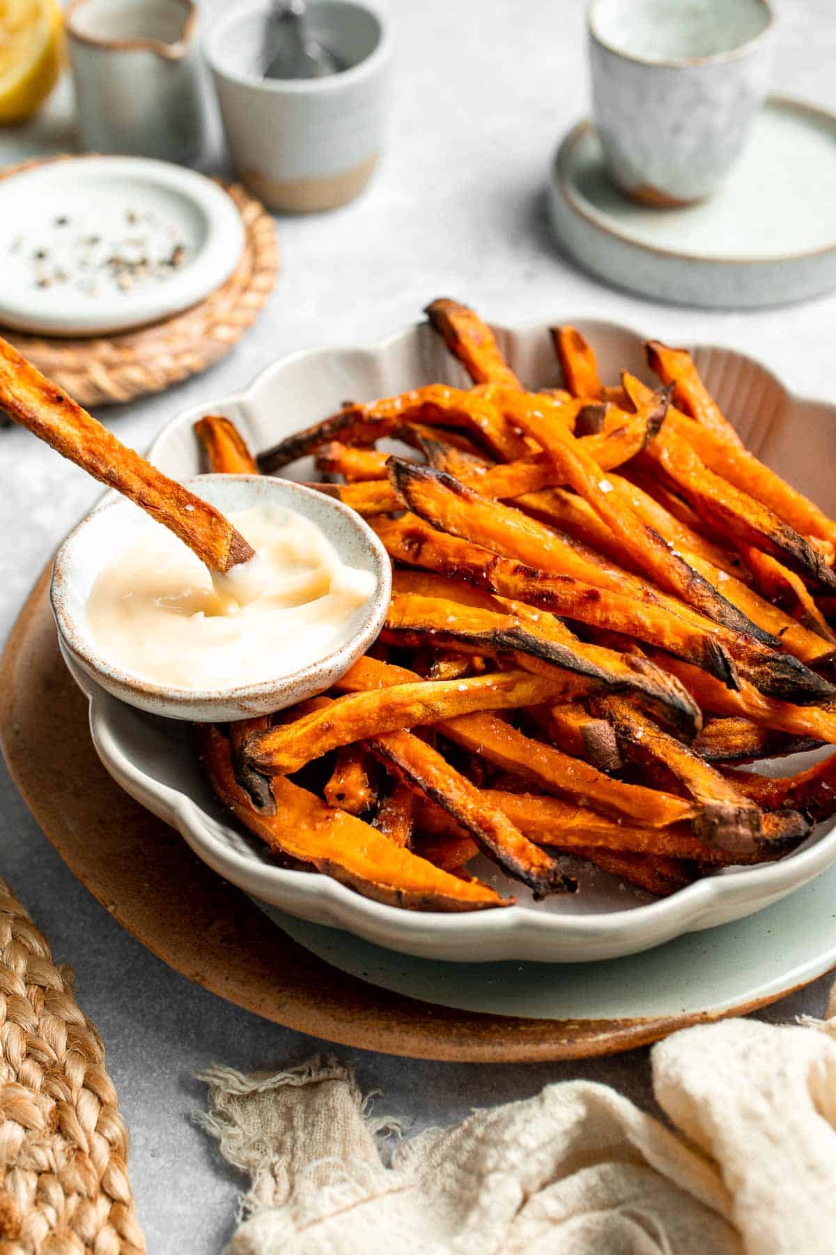 Indulge in these crispy and flavorful baked sweet potato fries, served with a creamy garlic aioli for the perfect combination of sweet and savory. | aheadofthyme.com