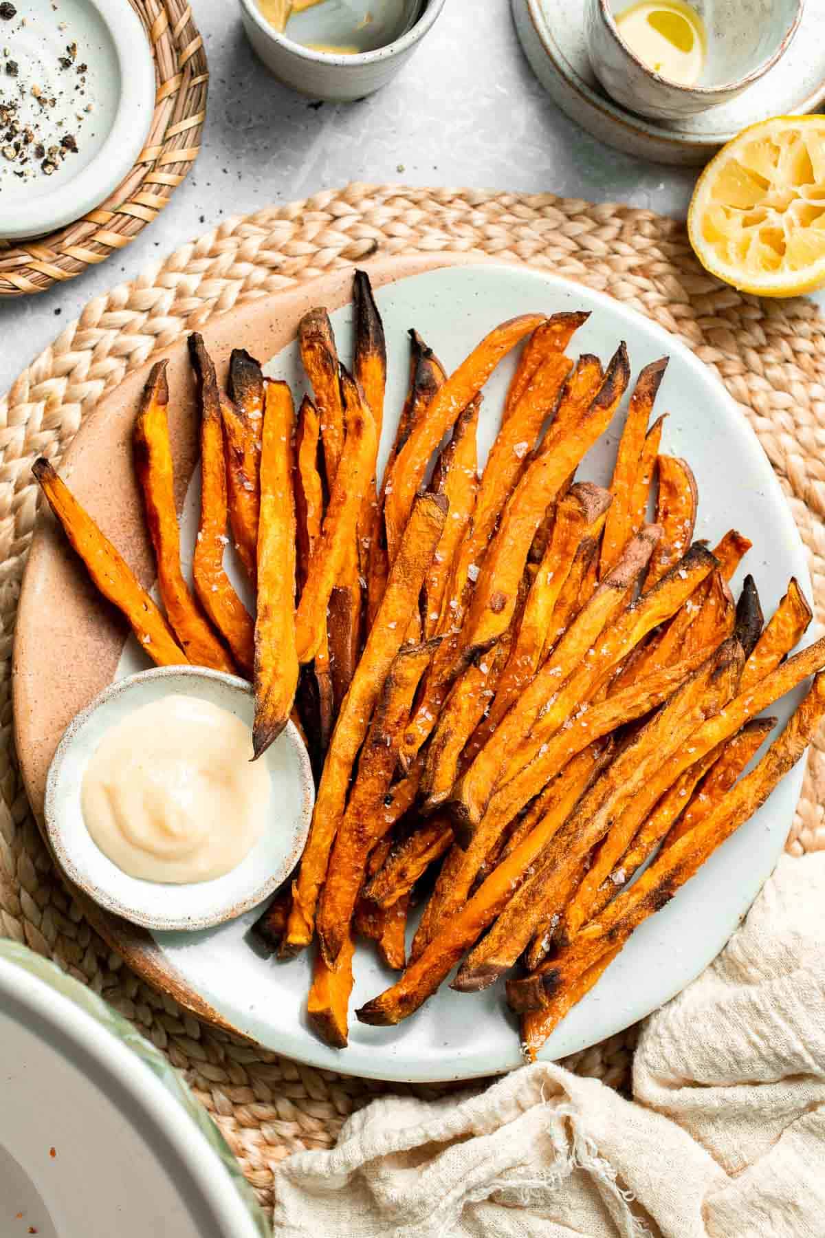 Indulge in these crispy and flavorful baked sweet potato fries, served with a creamy garlic aioli for the perfect combination of sweet and savory. | aheadofthyme.com