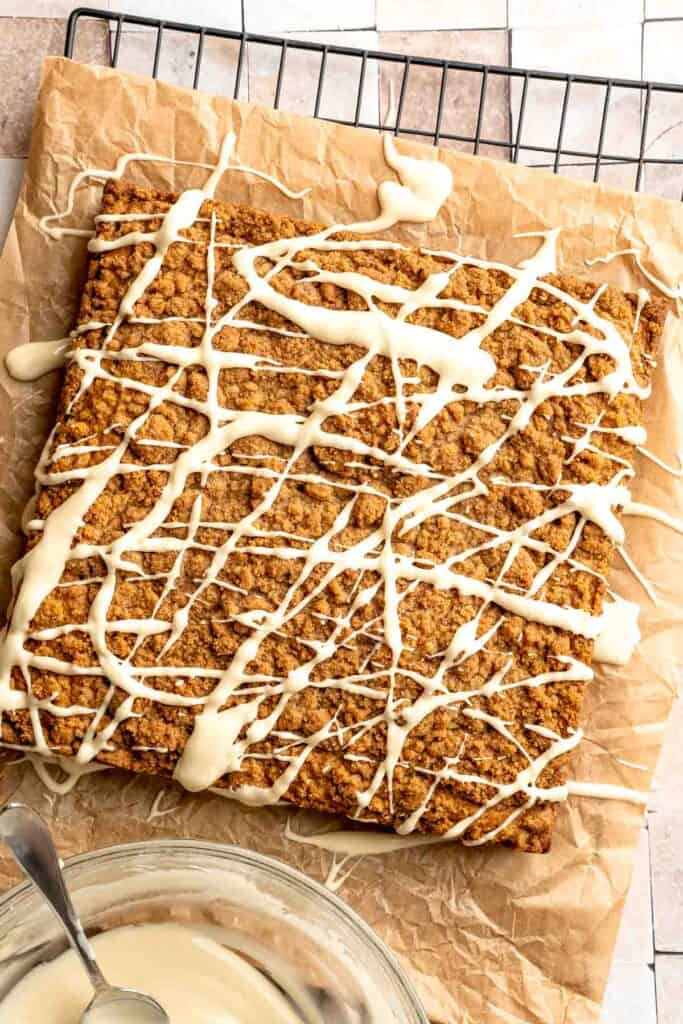 Pumpkin Coffee Cake, topped with a sweet and crunchy streusel and a maple glaze drizzle, is soft, moist, and filled with warm fall spices. | aheadofthyme.com