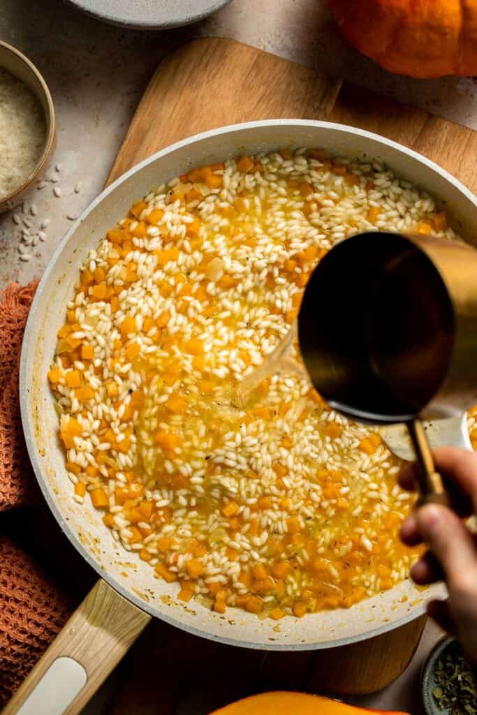 Enjoy a taste of fall with this creamy pumpkin risotto made with arborio rice, savory pumpkin, and aromatic herbs for a cozy, flavorful dish. | aheadofthyme.com