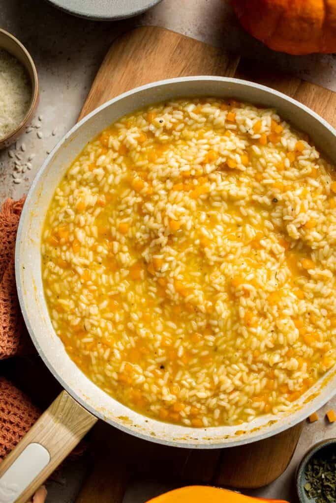 Enjoy a taste of fall with this creamy pumpkin risotto made with arborio rice, savory pumpkin, and aromatic herbs for a cozy, flavorful dish. | aheadofthyme.com