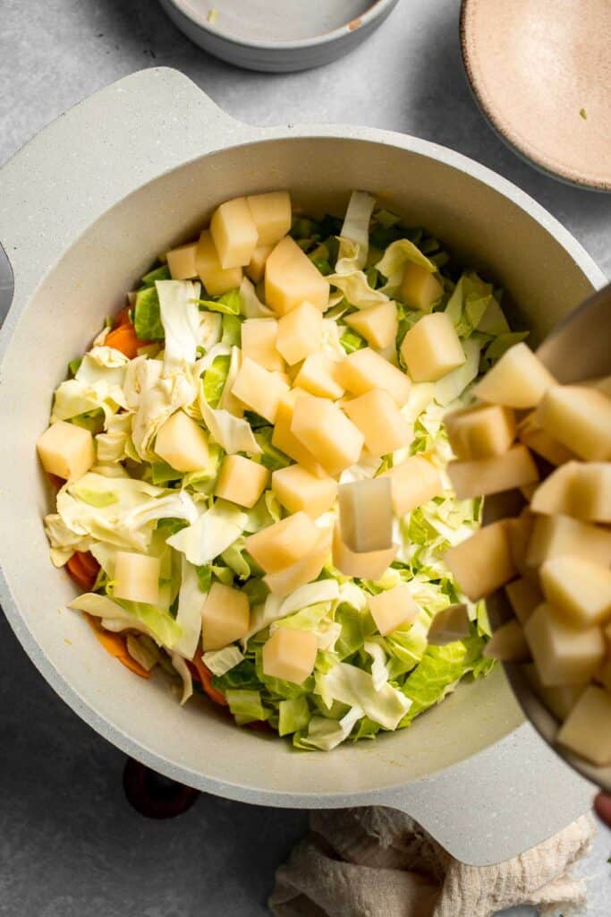 Warm up with this hearty and healthy vegetable cabbage soup packed with potatoes and carrots. A cozy one-pot meal ready in 30 minutes. | aheadofthyme.com