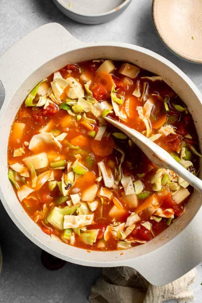 Warm up with this hearty and healthy vegetable cabbage soup packed with potatoes and carrots. A cozy one-pot meal ready in 30 minutes. | aheadofthyme.com