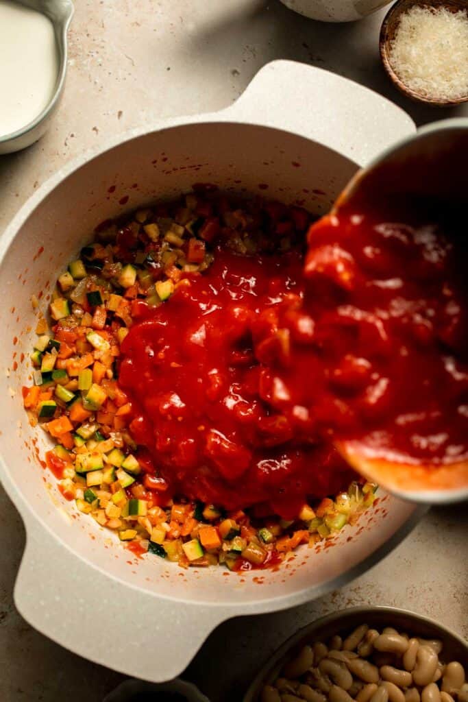 Creamy Tortellini Minestrone Soup is hearty, cozy, and loaded with veggies, beans, and cheese tortellini in a rich tomato-cream broth. | aheadofthyme.com