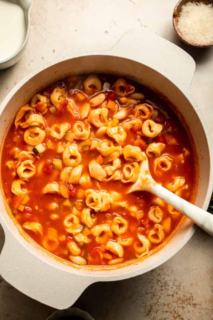 Creamy Tortellini Minestrone Soup is hearty, cozy, and loaded with veggies, beans, and cheese tortellini in a rich tomato-cream broth. | aheadofthyme.com