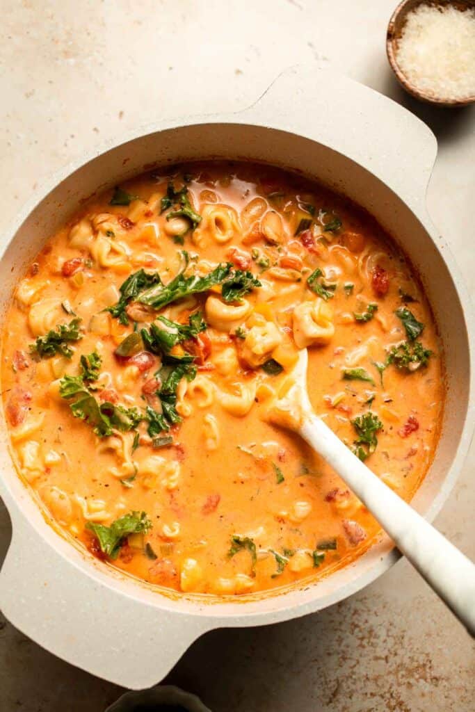 Creamy Tortellini Minestrone Soup is hearty, cozy, and loaded with veggies, beans, and cheese tortellini in a rich tomato-cream broth. | aheadofthyme.com