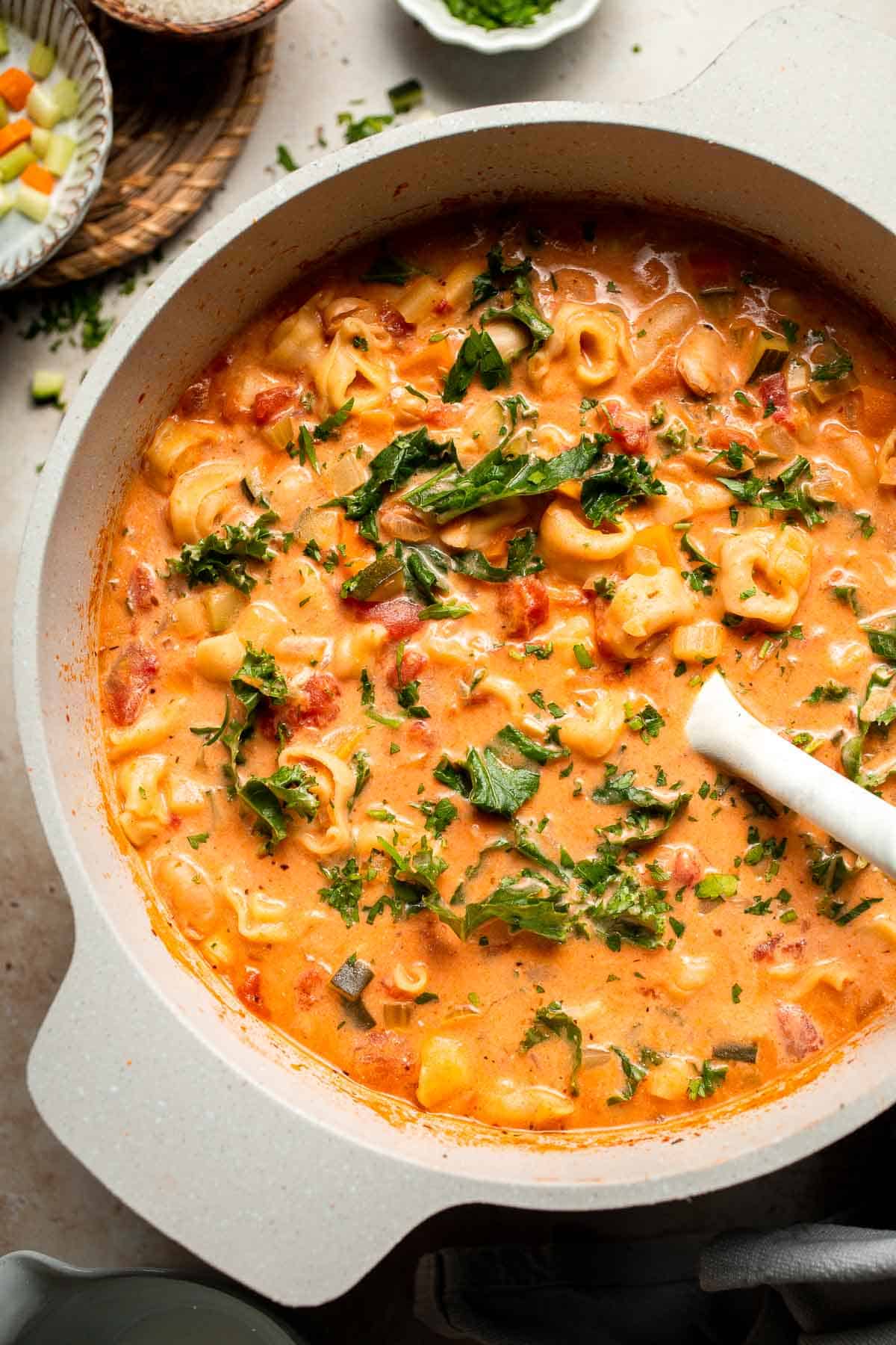 Creamy Tortellini Minestrone Soup is hearty, cozy, and loaded with veggies, beans, and cheese tortellini in a rich tomato-cream broth. | aheadofthyme.com