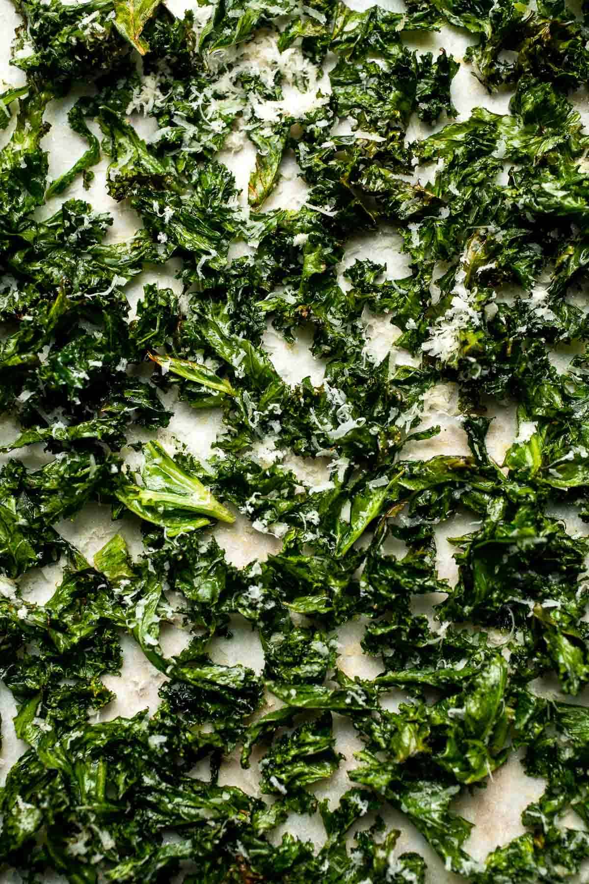 Crispy roasted kale made with olive oil, garlic, and parmesan. A quick and healthy side dish that bakes into perfectly crunchy, flavorful pieces. | aheadofthyme.com