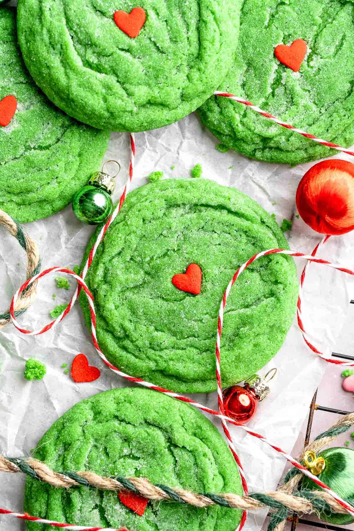 Grinch Cookies are soft, chewy green sugar cookies rolled in sparkly sugar and topped with a red heart. The cutest Christmas cookies for holiday baking. | aheadofthyme.com