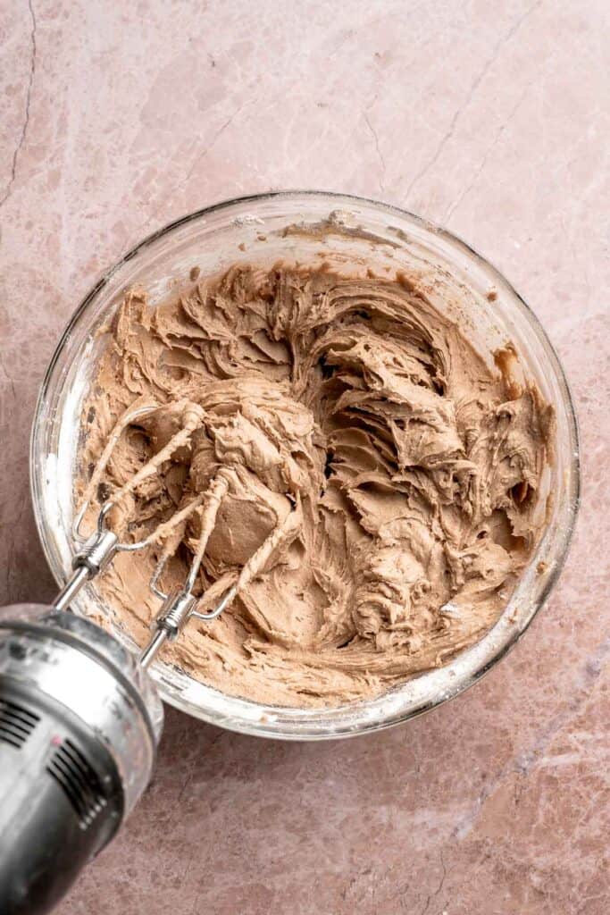 Hot chocolate macarons with cocoa shells and fluffy marshmallow filling. A cozy winter treat perfect for holiday baking and festive cookie trays. | aheadofthyme.com