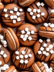 Hot chocolate macarons with cocoa shells and fluffy marshmallow filling. A cozy winter treat perfect for holiday baking and festive cookie trays. | aheadofthyme.com
