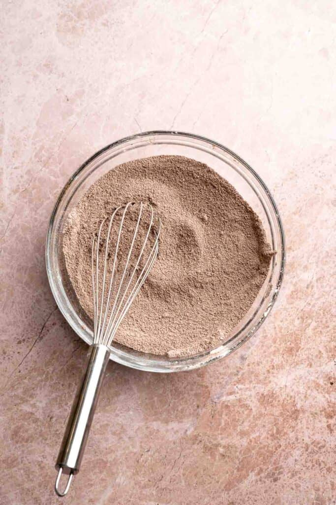 Hot chocolate macarons with cocoa shells and fluffy marshmallow filling. A cozy winter treat perfect for holiday baking and festive cookie trays. | aheadofthyme.com