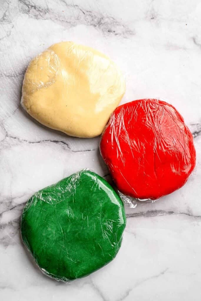 Peppermint pinwheel cookies with red, green, and white swirled dough rolled in festive sprinkles. A fun slice and bake Christmas cookie. | aheadofthyme.com