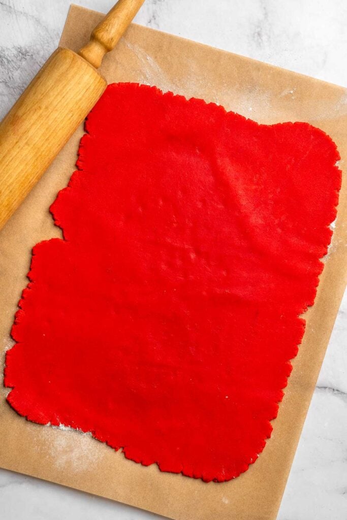 Peppermint pinwheel cookies with red, green, and white swirled dough rolled in festive sprinkles. A fun slice and bake Christmas cookie. | aheadofthyme.com