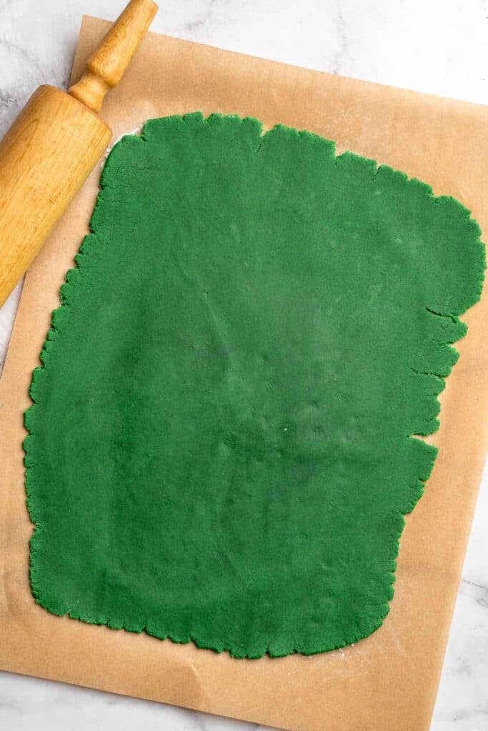 Peppermint pinwheel cookies with red, green, and white swirled dough rolled in festive sprinkles. A fun slice and bake Christmas cookie. | aheadofthyme.com